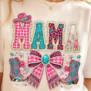 Könnte beinhalten: Ein cremefarbenes T-Shirt mit dem Wort MAMA in großen, dekorativen Buchstaben. Jeder Buchstabe hat ein einzigartiges Muster, darunter rosa Vichy-Karo, türkisfarbenes Filigran, rosa Leopardenmuster und florale Designs. Eine große rosa Vichy-Schleife mit türkisfarbener Mitte und zwei türkisfarbene Cowboystiefel befinden sich unter dem Text, alles akzentuiert mit künstlichen Perlen und Sternformen.