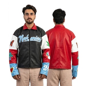 Può includere: Una giacca nera, rossa e bianca con la scritta "Nak mías" in blu. La giacca presenta un colletto rosso, un corpo nero e maniche bianche e rosse con toppe colorate. La giacca è mostrata davanti e dietro.