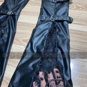 Puede incluir: Botas altas hasta el muslo de cuero sint&eacute;tico negro con detalles de hebilla. Las botas presentan un panel de encaje en la parte delantera y est&aacute;n dise&ntilde;adas con una silueta elegante y ajustada. Las botas tienen un aspecto deportivo.