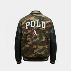 May include: A camouflage bomber jacket with black sleeves and trim. The back features the word "POLO" in large white letters above an embroidered image of a polo player on a horse. The jacket has a classic varsity style.