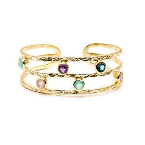 May include: A gold-toned cuff bracelet featuring a textured, hammered metal finish with three open bands. The piece is accented with six round, bezel-set gemstones in various colors, including purple, blue, light green, and pale pink hues.