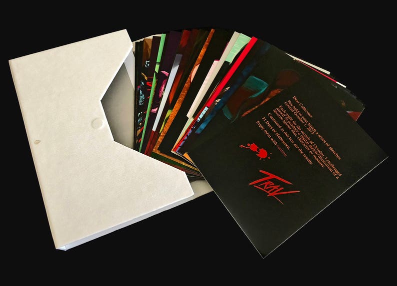 May include: A white envelope with a black button closure, containing a stack of black cards with red and white text. The text on the top card reads: "Dear Collectors, You hold in your hands a series of sketches created October 2013. Each image for the month of October, I challenged myself to create one (character) in the tradition of a 31 Days of Halloween. Contained in this book are the results. Enjoy them with..." The text is followed by the word "TRIAL" in red.