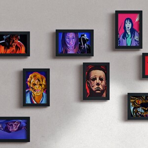 May include: A wall gallery of framed horror movie character portraits. The portraits are in a variety of colors, including red, blue, green, and black. The characters include Freddy Krueger, Jason Voorhees, Michael Myers, and more.