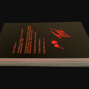 May include: A black book with a red title "Treat" and a red blood splatter design. The book has a text on the back cover that reads "Dear Collectors, You hold in your hands a series of sketches created October 1, 2013. Each night for the month of October I challenged myself to produce a digital sketch of my favorite horror film, character or moment. Contained in this box are the results. 31 Days of Halloween. Enjoy them with..."