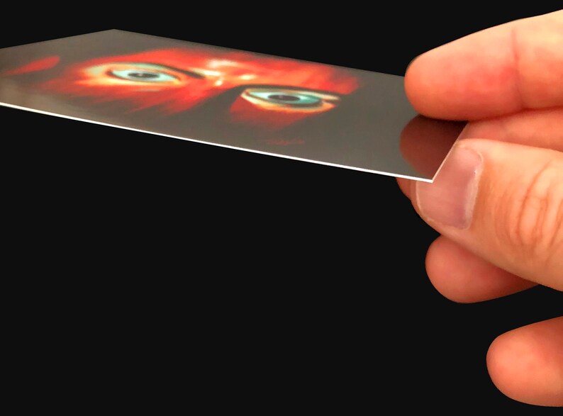May include: A close-up of a person's eyes, with one eye looking directly at the camera. The eyes are surrounded by red skin, and the background is dark.