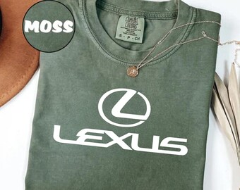 Könnte beinhalten: Moosgrünes T-Shirt mit weißem Lexus-Logo. Das Shirt hat einen Rundhalsausschnitt und kurze Ärmel. Eine goldene Halskette mit Anhänger ist auf dem Shirt drapiert. Das Wort "MOSS" befindet sich in einem Kreis oben links.