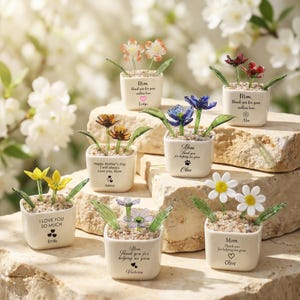 Puede incluir: Juego de tres tazas de cerámica con un esmalte moteado de color crema. Cada taza presenta un diseño floral pintado a mano en tonos azules, verdes y amarillos. Las tazas tienen una forma simple y redondeada, con asa.