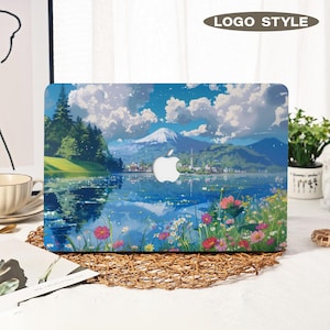 May include: Laptop case with a picturesque landscape design, showcasing a lake, mountains, and flowers. The artwork depicts a mountain range, a body of water, and a colourful floral meadow. The Apple logo is visible.