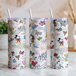 May include: Three white insulated tumblers with lids and straws, featuring a colorful Disney-themed design. The design includes Mickey Mouse, Minnie Mouse, and other characters, along with the text "Walt Disney World Disneyland".