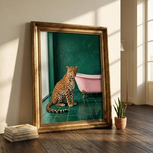 May include: A framed artwork featuring a leopard in a bathroom setting. The leopard is seated on a green tiled floor in front of a pink bathtub. The artwork is in a gold frame and leans against a wall.
