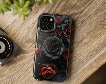 May include: A black smartphone case featuring a dark floral design of red and black roses. The case has a glossy finish and is set against a wooden background. The phone's camera lenses are visible.