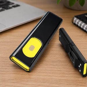 May include: Two black rectangular flashlights with bright yellow accents. The larger flashlight features a prominent yellow oval panel on its front surface, while the smaller flashlight includes a side clip and a yellow light strip at the end.