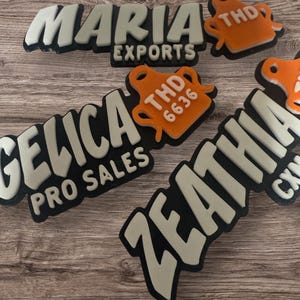 May include: Three custom rubberized patches featuring raised lettering and logos. One reads MARIA EXPORTS, another GELICA PRO SALES, and the third ZEATHIA. Each includes a small orange icon with the text THD or THD 6636 in white raised letters.