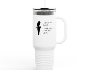 May include: White travel mug with a black silhouette of a person and the text "I USED TO CARE. I TAKE A PILL FOR THAT NOW." The mug has a handle, a silver lid, and a white straw.
