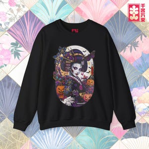 Puede incluir: Sudadera negra con un diseño de geisha con temática de Halloween. La geisha tiene la piel pálida y maquillaje oscuro, con calabazas, murciélagos y mariposas a su alrededor. El diseño está ambientado contra una luna llena.