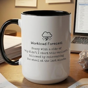 May include: A white ceramic mug with a black handle and interior rim. The mug features a black graphic of a storm cloud with lightning and the text: Workload Forecast: Heavy with a side of 'why didn't I start this earlier?' followed by reinventing the wheel at the last minute.