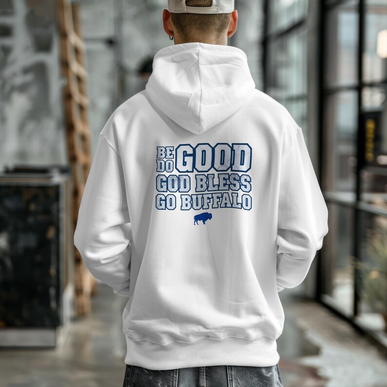 Puede incluir: Sudadera con capucha blanca con texto azul en la espalda que dice "BE DO GOOD GOD BLESS GO BUFFALO" con un gr&aacute;fico de b&uacute;falo. La sudadera tiene una capucha con cord&oacute;n y un bolsillo de canguro.