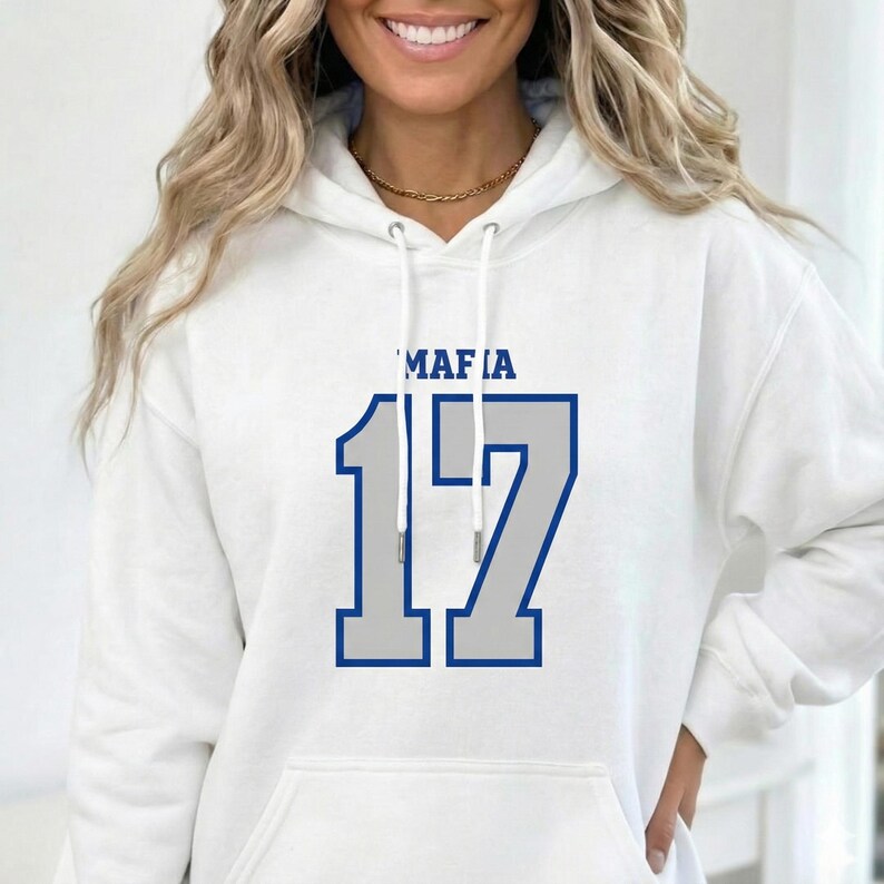 Puede incluir: Sudadera con capucha blanca con la palabra "MAFIA" encima del n&uacute;mero "17" en un dise&ntilde;o azul y gris. La sudadera tiene una capucha con cord&oacute;n y un bolsillo delantero.