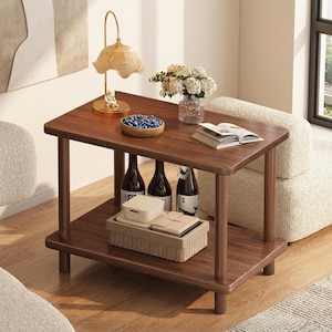 Peut inclure: Une table d'appoint en bois foncé à deux niveaux, avec un plateau rectangulaire et une étagère inférieure. La surface supérieure contient une lampe décorative, un bol de myrtilles et un vase de fleurs. L'étagère inférieure affiche des bouteilles de vin et des contenants de rangement.