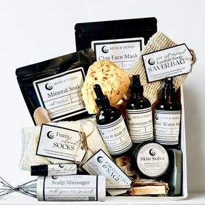 May include: A gift set featuring skincare products from Moss & Moon. The set includes bottles of face and body oil, magnesium mist, and rose water mist, along with a skin salve, loofah soap, and a clay face mask. Also included are fuzzy socks and a scalp massager.
