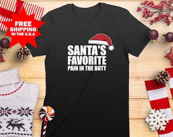 Santa's Favorite Pain in the Butt Funny T-Shirt, Christmas Humor Tee, Festive Holiday Shirt, Santa Hat Tee, Gift for Troublemakers T-Shirt