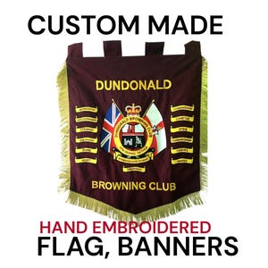 May include: A custom-made burgundy flag with gold fringe. The flag displays "Dundonald Browning Club" in gold lettering, with a central emblem. The text "Hand Embroidered Flag, Banners" is at the bottom. The flag has a rectangular shape.