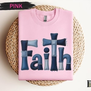 A pink t-shirt with the word "Faith" written in a stylized font made up of blue denim pieces.