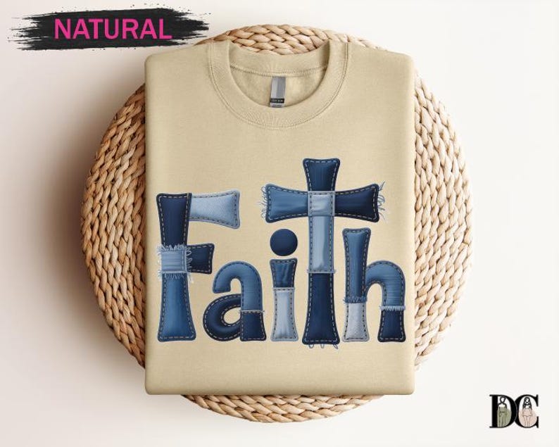 A beige t-shirt with the word "Faith" written in blue letters, along with a cross design, is displayed on a woven placemat.