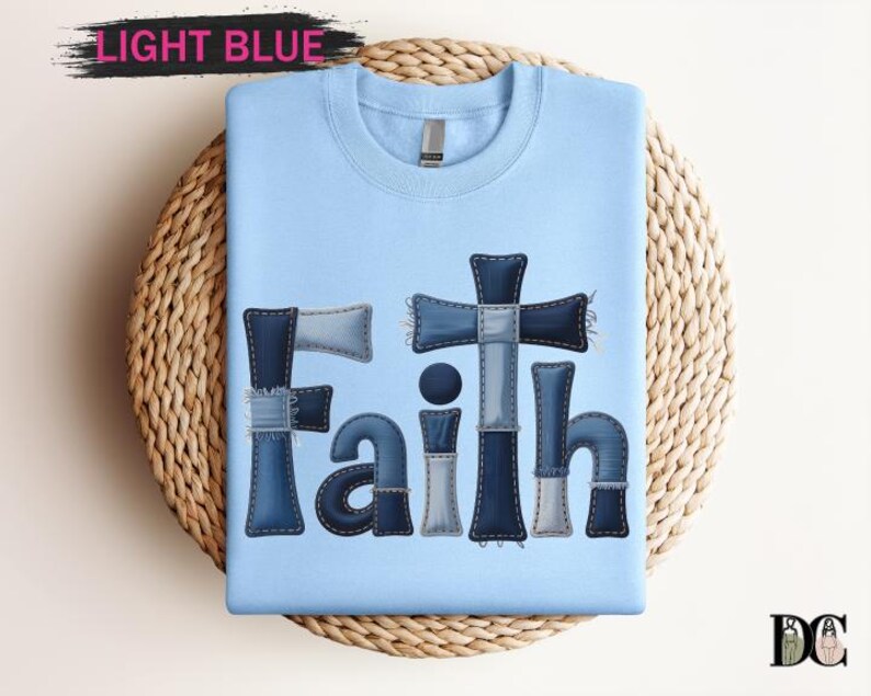 A light blue t-shirt with the word "Faith" printed in a patchwork style, made up of various fabric pieces in shades of blue and gray.