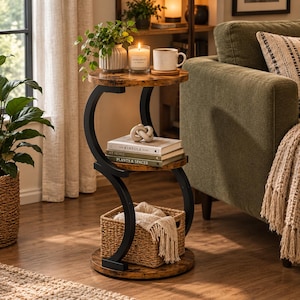 May include: A three-tier side table with a black metal S-shaped frame and round rustic brown wood-grain shelves. The top shelf holds a potted plant, a candle, and a mug. The middle shelf holds two books and a decorative knot. A woven basket sits on the base.