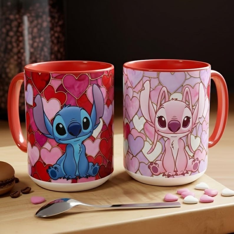 May include: Two ceramic mugs with red interiors and handles. One mug features a blue cartoon character on a background of red and pink hearts. The other mug has a pink cartoon character on a background of pink and purple hearts.