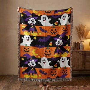 May include: A woven throw blanket featuring a repeating Halloween pattern with Mickey Mouse dressed as a wizard, white ghosts, orange jack-o'-lanterns, purple bats, yellow stars, and candy corn on alternating black and orange horizontal stripes.