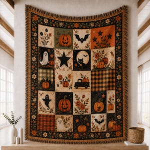 May include: A woven throw blanket featuring a patchwork design with Halloween motifs including jack-o'-lanterns, ghosts, black cats, bats, stars, and floral patterns. The blanket has a fringed edge and a colour palette of orange, black, and cream.