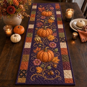 Può includere: Un runner da tavola trapuntato rettangolare con un pannello centrale viola scuro decorato con zucche arancioni, foglie autunnali e fiori. Il bordo è costituito da un motivo patchwork di piccoli quadrati nei toni dell'arancione, marrone e crema.