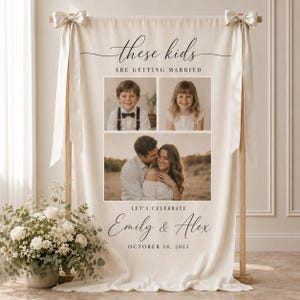 Pode incluir: Uma faixa de tecido cor de creme pendurada num suporte de madeira com fitas de cetim brancas. Apresenta o texto "these kids ARE GETTING MARRIED", três fotografias de um casal e o texto "LET'S CELEBRATE Emily & Alex OCTOBER 18, 2025".