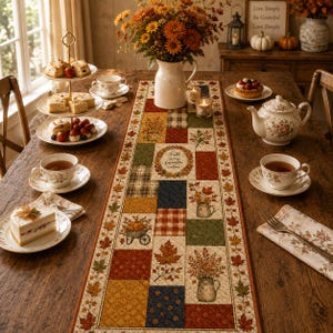 May include: A rectangular quilted table runner featuring a patchwork design of autumn-themed squares, including maple leaves, pumpkins, and floral arrangements, with the text "Fall is my favorite color" centered on a cream-colored background.