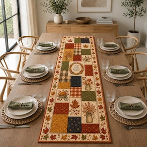 May include: A rectangular table runner featuring a patchwork design with autumn-themed motifs including maple leaves, pumpkins in a wheelbarrow, and floral arrangements in pitchers. The center text reads, Fall is my favorite color.