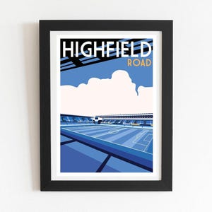 Può includere: Una stampa d'arte incorniciata con un'illustrazione stilizzata dello stadio Highfield Road. Il grafico mostra un campo da calcio blu, tribune con il testo CCFC SKYBLUES e le parole HIGHFIELD ROAD in bianco e giallo.