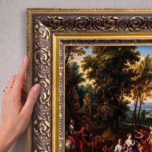May include: A rectangular wall art piece featuring a landscape painting with figures in a forest setting, enclosed in an ornate, dark brown and gold-toned frame with intricate relief carvings along the edges and a smooth inner gold border.