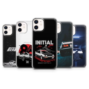 Könnte beinhalten: Eine Sammlung von Handyhüllen mit Autodesigns. Die Hüllen zeigen Grafiken von Autos, Bergen und japanischem Text. Die Farbpalette umfasst Schwarz, Weiß, Rot und Blau. Der Text "INITIAL DREAMS" ist auf einer Hülle zu sehen.