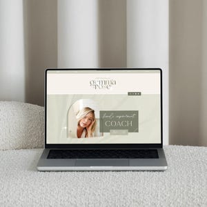 May include: A silver laptop displaying a website with the text "gemma pose" and the words "hand reparent coach". The website features a photo of a woman with blonde hair. The laptop is on a white textured surface.