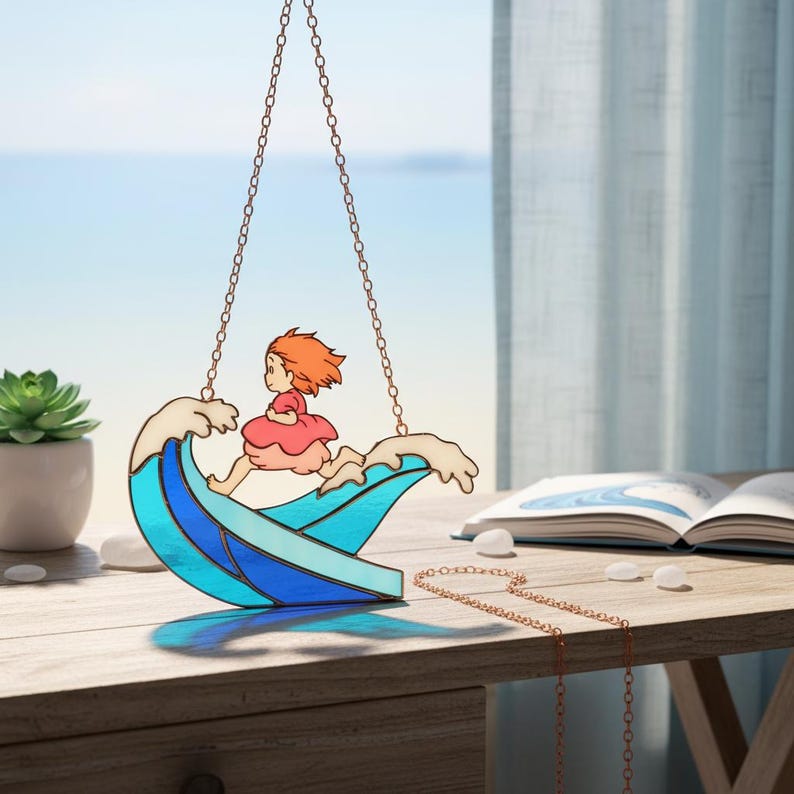 May include: Stained glass suncatcher depicting a girl running on a wave. The wave is blue and white, with the girl in a pink dress and orange hair. It hangs from a copper chain, suitable for a window or wall decoration.