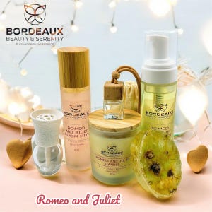 Può includere: Una collezione di prodotti Bordeaux Beauty & Serenity, tra cui un room mist, una candela e sapone, con il testo "Romeo and Juliet". I prodotti sono disposti su una superficie rosa con cuori decorativi e luci fatate.