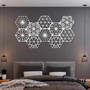Puede incluir: Arte de pared geométrico blanco compuesto por formas hexagonales interconectadas con patrones intrincados. El diseño presenta motivos de explosiones de estrellas y estrellas geométricas, creando una pieza de decoración mural moderna y artística.