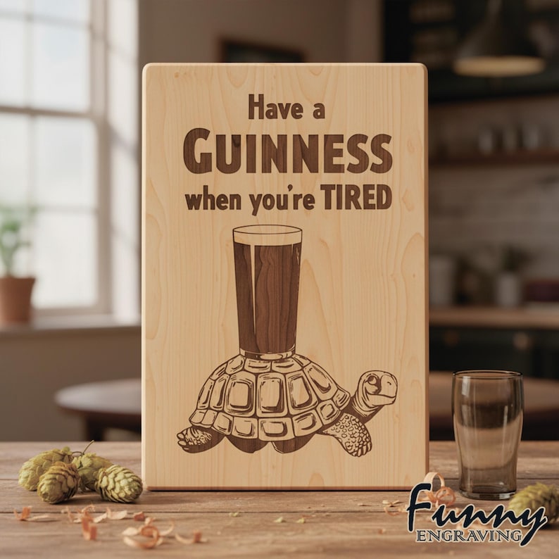 May include: Wooden sign with the text "Have a Guinness when you're TIRED". The sign features an engraved image of a pint of Guinness atop a turtle. The sign is made of light-coloured wood.