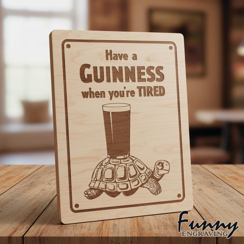 May include: A rectangular wooden sign with the text "Have a Guinness when you're TIRED". The sign features a Guinness pint glass on a turtle. The sign is made of light-coloured wood.