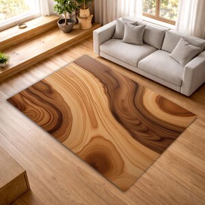 May include: A rectangular area rug with a wood grain design in shades of brown and tan. The rug is placed on a hardwood floor in a living room setting, with a light-colored sofa and window in the background.