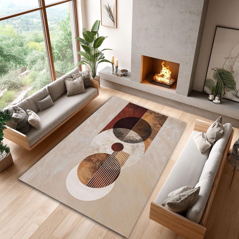 May include: A rectangular area rug with a geometric design in shades of brown, beige, and white. The rug features circles, semi-circles, and lines arranged in an abstract pattern. The rug is placed in a living room setting with a sofa and fireplace.