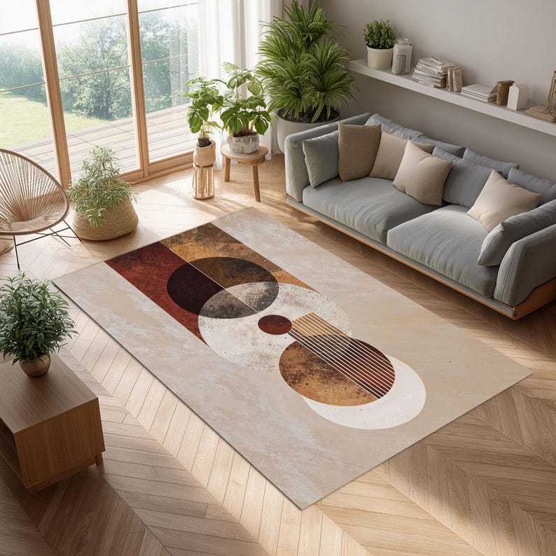 May include: A rectangular area rug with a geometric design in shades of brown, beige, and white. The rug features overlapping circles and rectangles, creating an abstract pattern. The rug is placed on a wooden floor in a living room setting.