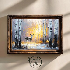 May include: A framed painting depicts a deer in a snowy forest with birch trees. The artwork features a warm, golden light filtering through the trees, creating a serene and natural scene. The frame is a dark brown color.
